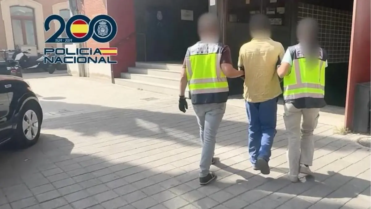 The detained man being escorted by officers. Image distributed with the police information about the Huércal-Overa case. Photo: Policía Nacional.