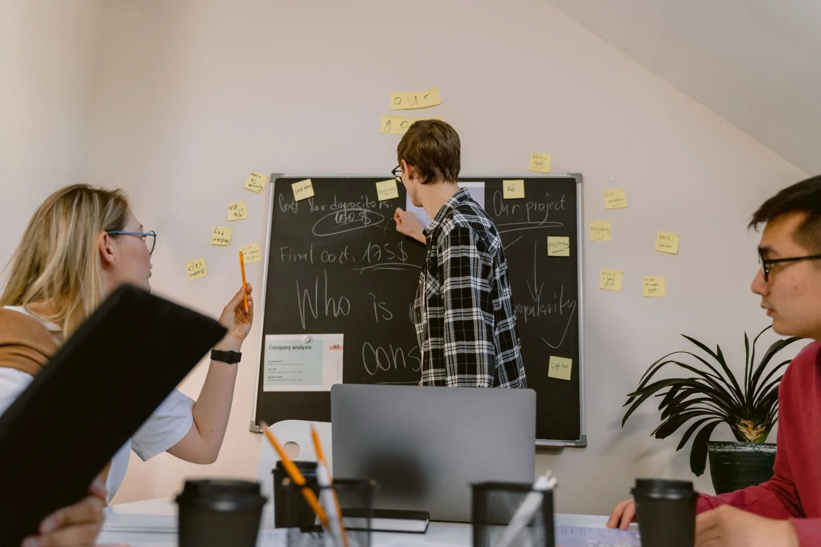 Team meeting with a blackboard. Stock photograph illustrating staff learning, not the Home Office programme.