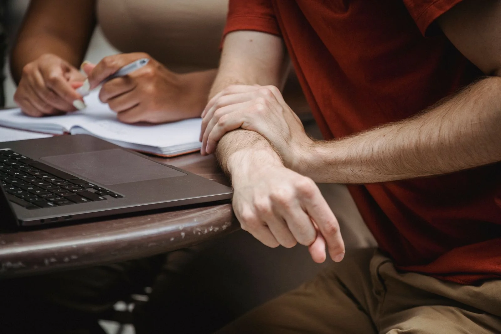 Students working with a laptop and notes. Stock photograph of a learning environment; the people are not connected to the report.