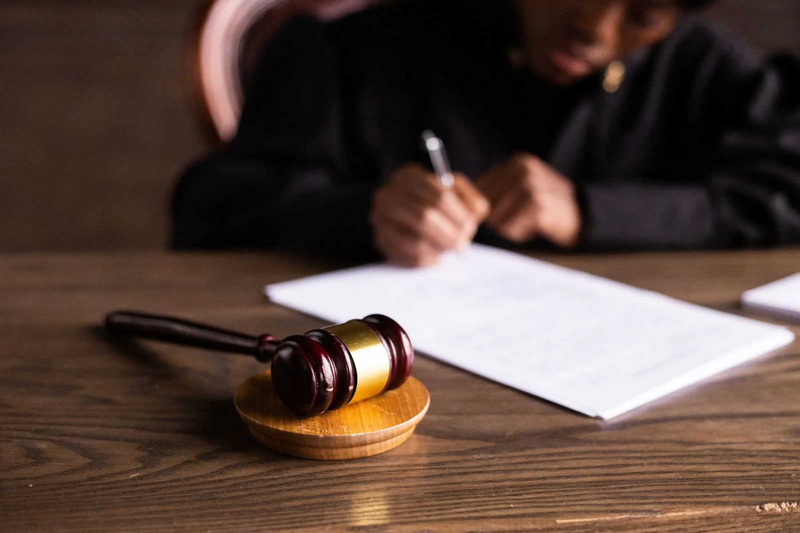 Documents being signed in a staged legal setting. Stock photograph, not the commissioner or the parliamentary proceedings.